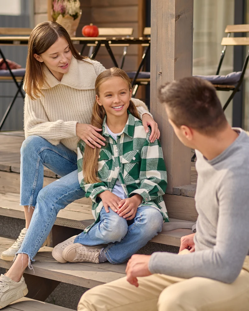 Happy family supporting a girl with type 1 diabetes outdoors.