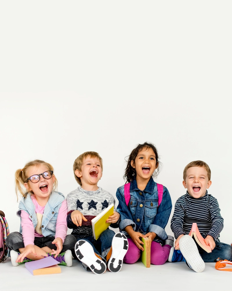 Group of happy children sitting together and laughing.