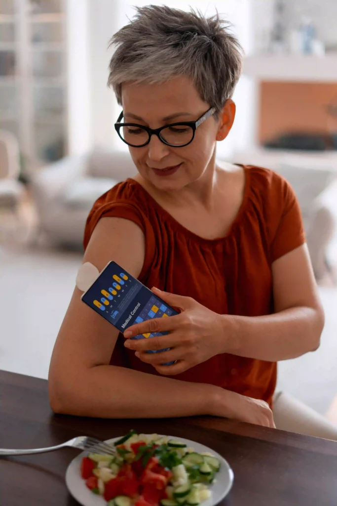 Woman checking glucose levels with a smartphone app and arm sensor before eating a healthy meal.